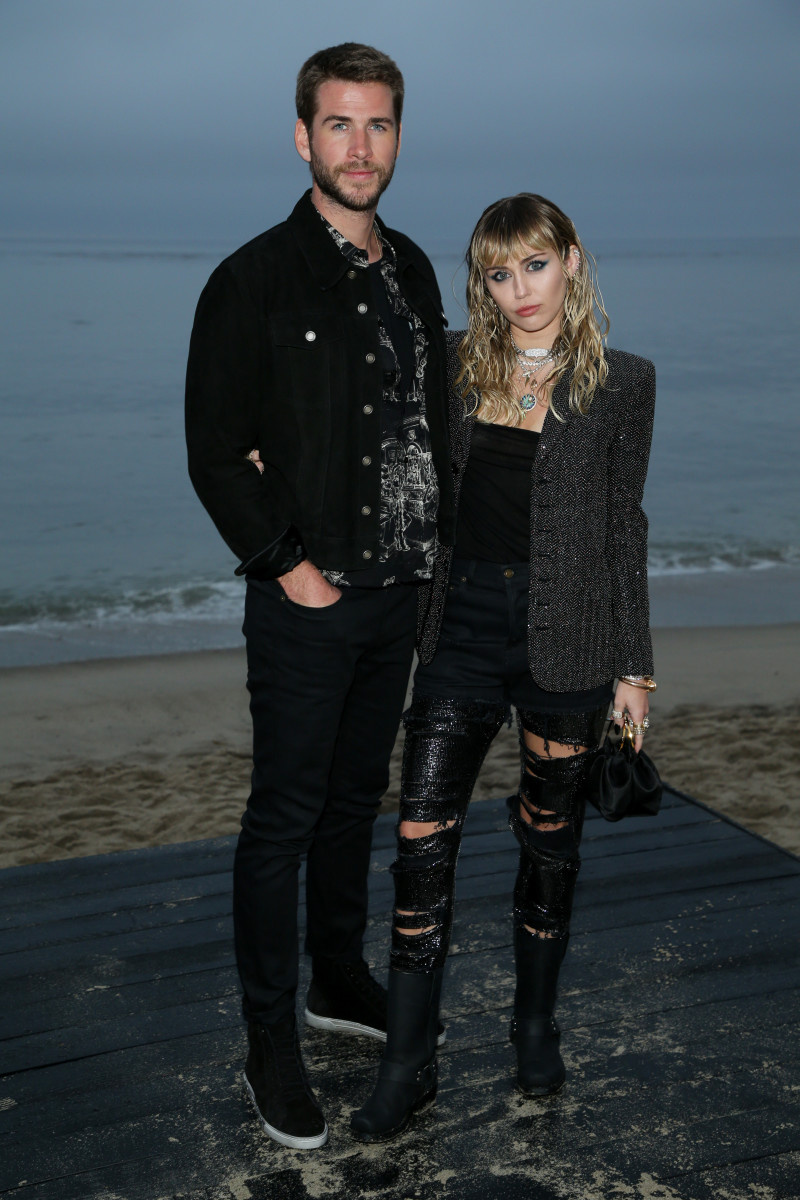   Miley Cyrus ir Liamas Hemsworthas atvyksta į „Saint Laurent Men“.'s Spring-Summer 2019 runway show in Malibu, California, on June 6, 2019. (Photo by Kyle GRILLOT / AFP) (Photo credit should read KYLE GRILLOT/AFP via Getty Images)