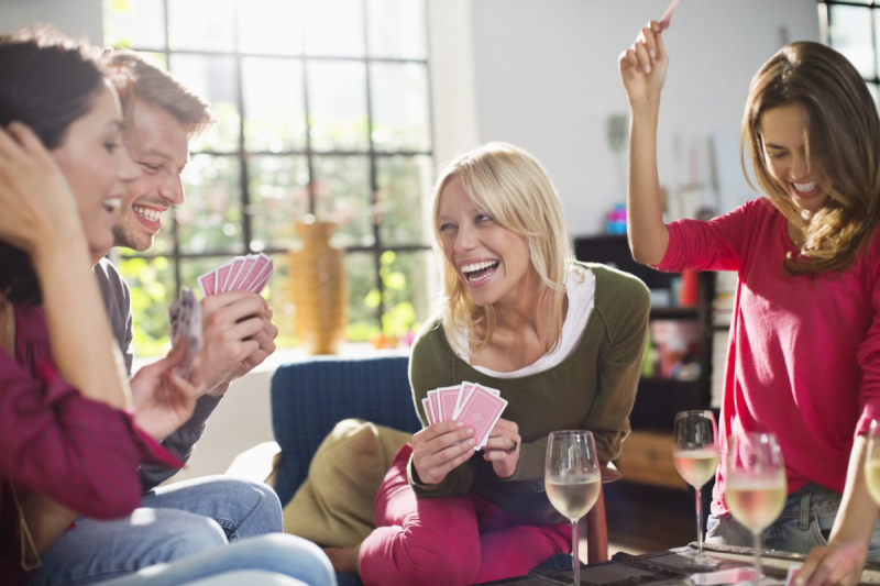   grupp vänner spelar dricka kortspel