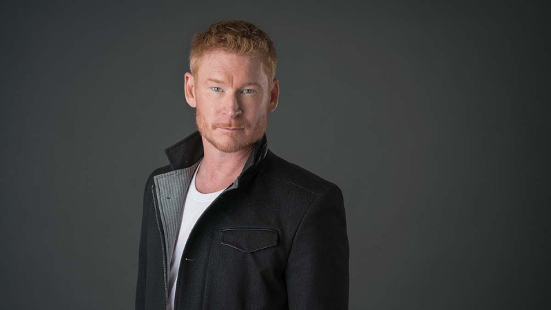 Zack Ward indossa una giacca nera con fodera grigia e una maglietta bianca