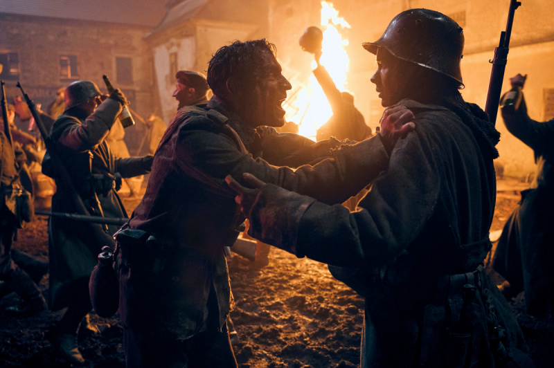  Netflixの第一次世界大戦での戦いの後、フェリックス・カメラーと他の兵士が火の周りで祝う's "All Quiet on the Western Front" (2022)