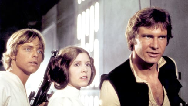  Amerikiečių aktoriai Markas Hamillas, Carrie Fisher ir Harrisonas Fordas filmavimo aikštelėje „Žvaigždžių karai: Epizodas IV – nauja viltis“ parašė, režisavo ir prodiusavo Georgesas Lucasas.