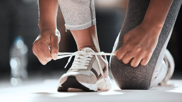  спортиста везује ципеле и спрема се да уради вежбу супермена