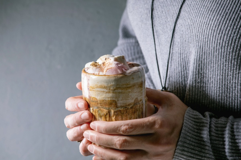  Kvinde i grå sweater holder i hænderne keramisk krus med varm chokolade eller kakao med skumfidus.. (Foto: Natasha Breen/REDA&CO/Universal Images Group via Getty Images)