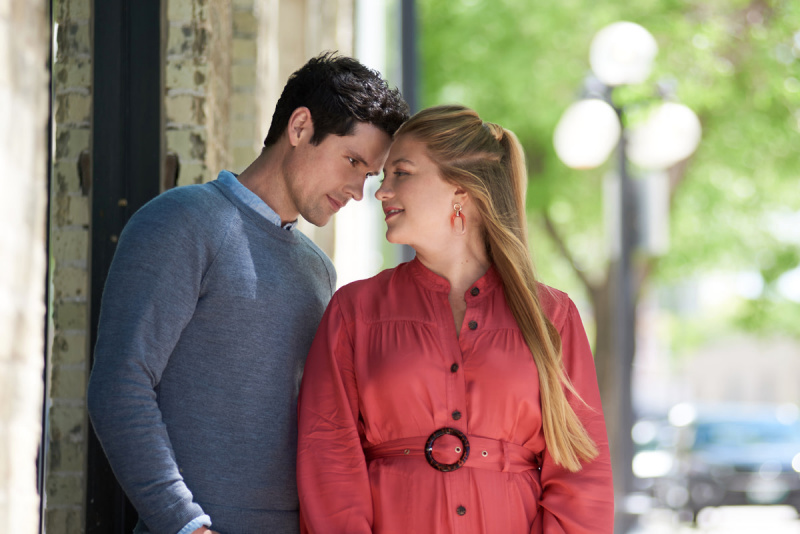  Im Hallmark-Film"Romance in Style," Benjamin Hollingsworth as Derek and Jacy Elliot as Ella are outdoors looking into each others eyes.